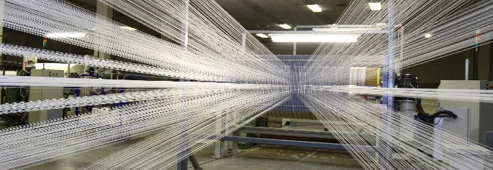 Weiße Fäden in einer Produktionshalle